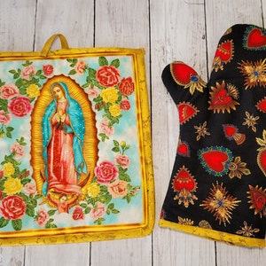 Peut inclure: Un ensemble de deux accessoires de cuisine sur le thème religieux. Un gant de four noir avec des cœurs rouges et des accents dorés et un dessous de plat avec une image colorée de la Vierge Marie entourée de roses.