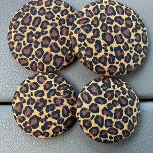 May include: Four round, brown and black leopard print fabric buttons.