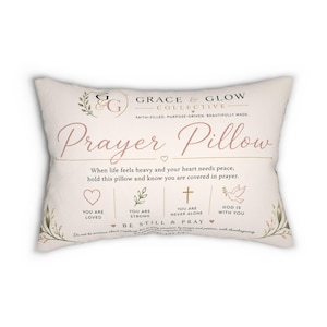 May include: A rectangular off-white throw pillow featuring the text Grace & Glow Collective and Prayer Pillow. The design includes a heart, a cross, and a dove icon with the phrases You Are Loved, You Are Strong, You Are Never Alone, and God Is With You, along with floral accents and the scripture reference Philippians 4:6.