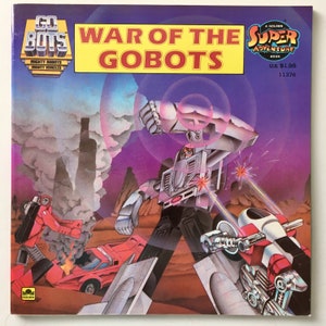 May include: A comic book cover featuring a silver robot with a red and white robot in the foreground. The title of the book is "War of the Gobots" and it is a Golden Super Adventure Book.