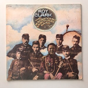 Puede incluir: Una portada de álbum vintage con una banda en uniformes militares. El álbum se titula "Roy Clark The Magnificent Sanctuary Band".