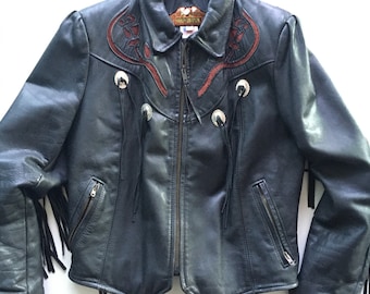 May include: A black leather jacket with fringe detailing and embroidered floral designs. The jacket has a zipper closure and a collar. The label reads "Harley Davidson".