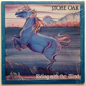 May include: A vintage vinyl record album cover featuring a blue horse with a red mane jumping against a sunset background. The album title is "Stone Oak" and the album name is "Riding with the Wind".