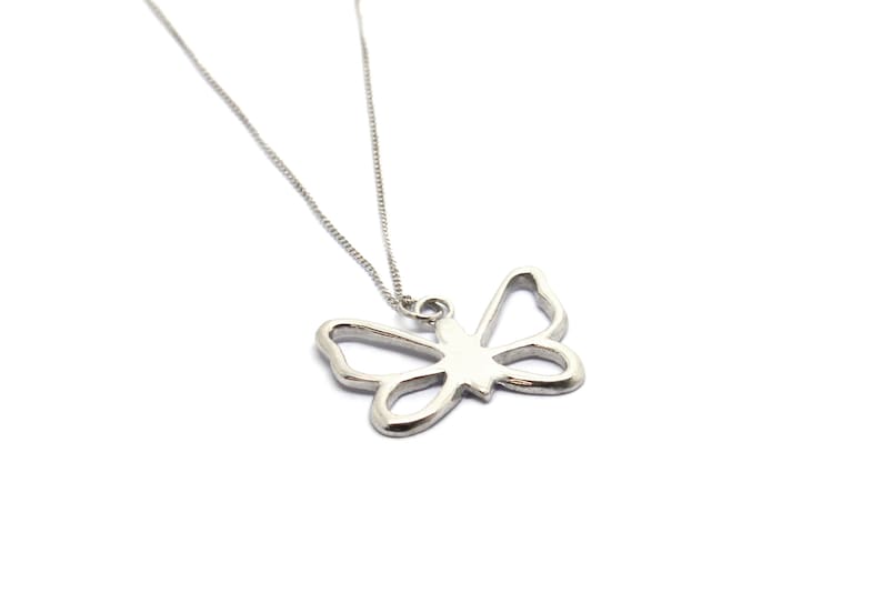 May include: A silver necklace with a delicate butterfly pendant. The butterfly is cut out of the metal, creating a delicate and airy look.