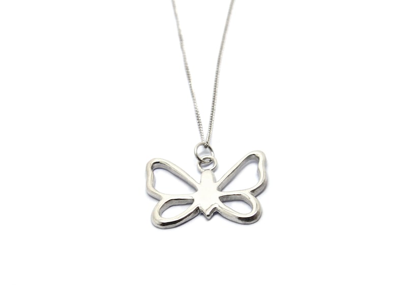 May include: A silver chain necklace with a delicate butterfly pendant. The butterfly is cut out, creating a delicate and airy look.