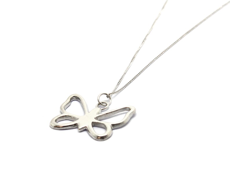 May include: A silver necklace with a delicate butterfly pendant. The butterfly is a cutout design, creating a delicate and airy look.