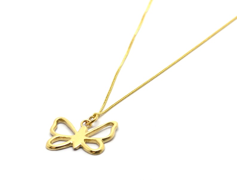 May include: A gold chain necklace with a delicate butterfly pendant. The butterfly is a simple outline with no details.