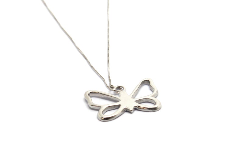 May include: A silver necklace with a delicate butterfly pendant. The butterfly is a simple outline with no details.