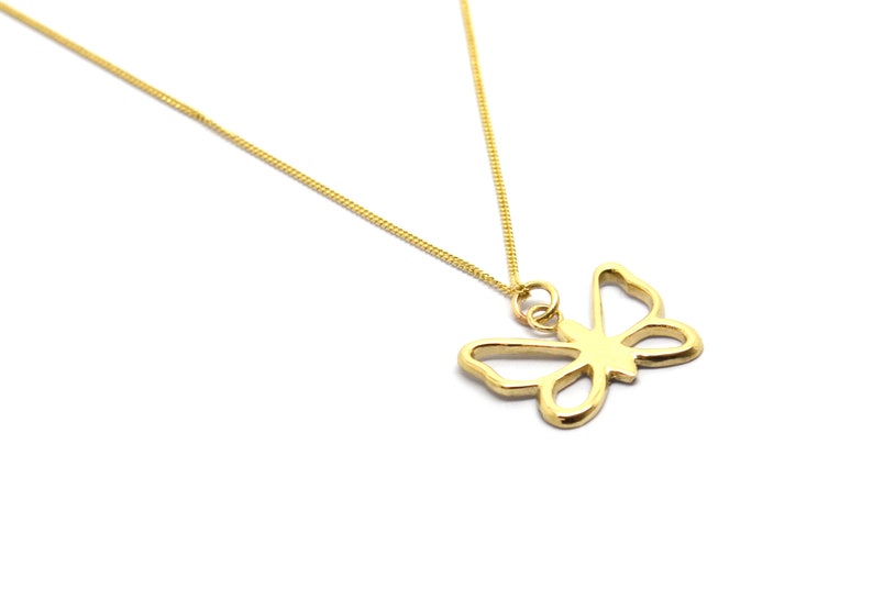 May include: A gold chain necklace with a delicate butterfly pendant. The butterfly is a simple outline design.