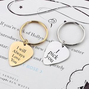 May include: Two gold and silver guitar pick keychains with the text "I will always love you" and "I pick you" on them.