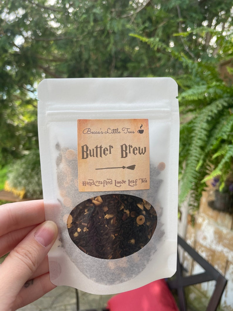 May include: A white resealable pouch with a label that reads "Becca's Little Teas" and "Butter Brew Handcrafted Loose Leaf Tea". The pouch contains loose leaf tea with a brown, black, and beige color.