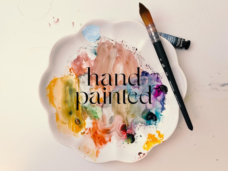 a plate with a paintbrush and the words hand painted on it