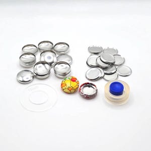以下が含まれることがあります： クラフトや衣料品プロジェクト用の銀色の金属製スナップファスナーのセット。セットにはさまざまなサイズとスナップを取り付けるためのツールが含まれています。