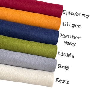 May include: A selection of felt fabric rolls in shades such as spiceberry, ginger, heather navy, pickle, grey, and ecru. The colour names are displayed in a handwritten font on the right side of the image.