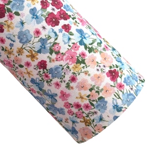 Peut inclure: Un tissu blanc avec un motif floral composé de fleurs bleues, roses et rouges. Le tissu est recouvert d'une variété de petites fleurs.