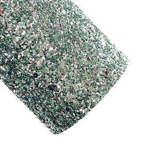 May include: A close-up of a sheet of green glitter fabric. The glitter is a mix of silver and green, creating a shimmering effect.
