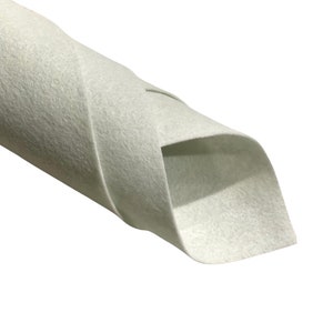 May include: A roll of white felt fabric. The fabric is rolled up and the end is folded over.