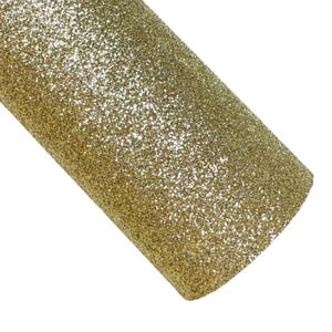 May include: A sheet of gold glitter fabric with a fine, even texture. The glitter is densely packed and creates a shimmering effect.