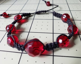Adjustable length macrame hemp cord bracelet, with faceted red glass beads