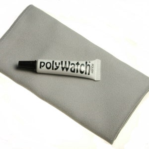 Può includere: Un panno in microfibra grigio e un tubo bianco di lucidante PolyWatch. Il tubo ha un tappo nero e le parole "PolyWatch Polish" stampate su di esso.