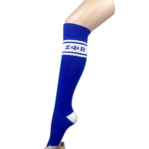 May include: Blue knee-high socks with a white stripe and the letters "ZΦB" in blue.