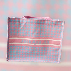 May include: A pink and blue checkered tote bag with white stripes and the text "Jack And Jill 1938" printed on the front.