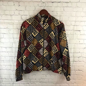 May include: A brown, black, red, and gray patterned bomber jacket with a zipper closure. The jacket has a stand-up collar and long sleeves.