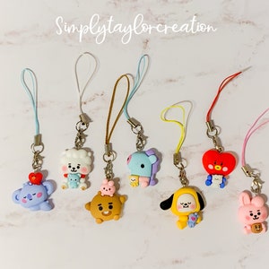 May include: A collection of colorful character charms with attached lanyards. The charms feature various cartoon figures in shades of blue, yellow, brown, red, and pink. The text "Simplytaylorcreation" is written in cursive at the top.