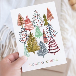 May include: A white card with a festive illustration of colorful Christmas trees and the text "HOLIDAY CHEER".