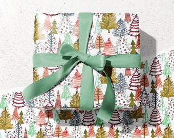 May include: A wrapped gift box with a green ribbon bow. The wrapping paper features a repeating pattern of colorful Christmas trees in red, green, gold, and blue on a white background. The text "kelseymdesigns" is in the top left corner.