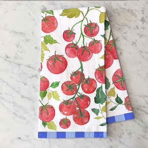 May include: White kitchen towel with a watercolor design of red tomatoes on vines with green leaves. The towel has a blue and white striped border. A decorative and functional kitchen accessory.