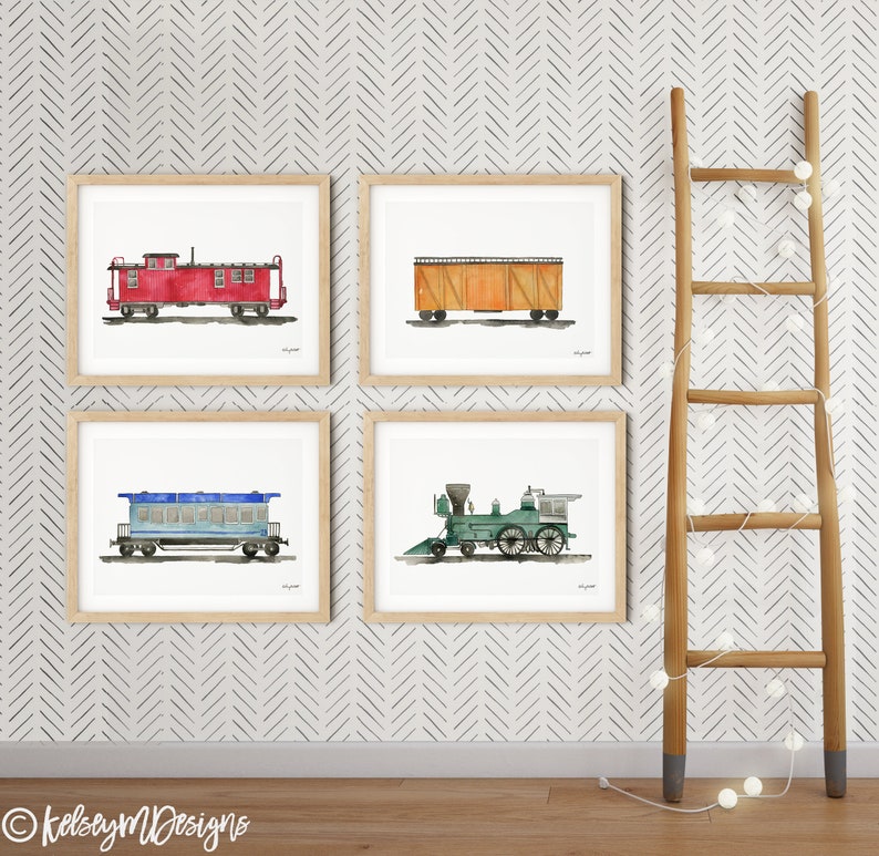 May include: Four framed watercolor illustrations of vintage train cars and a locomotive. The illustrations are in a light brown frame and are hung on a white wall with a chevron pattern. A wooden ladder with white lights is leaning against the wall.