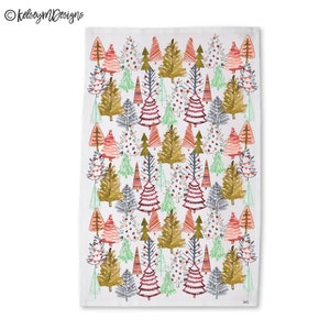 May include: White rectangular kitchen towel with a repeating pattern of stylized Christmas trees in various colors. The trees are in shades of red, green, gold, and gray, with some decorated with ornaments. The towel has the text "KelseyMDesigns" in the upper left corner.