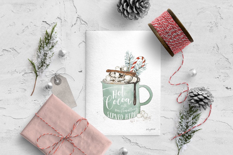 Puede incluir: Una tarjeta blanca con una ilustraci&oacute;n de acuarela de una taza verde llena de chocolate caliente, malvaviscos, crema batida, un palo de canela y un bast&oacute;n de caramelo. El texto en la tarjeta dice "Hot Cocoa with marshmallows SERVED HERE".