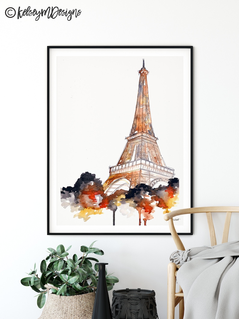 May include: Watercolor painting of the Eiffel Tower in shades of orange, yellow, and brown. The tower is depicted against a white background with a watercolor wash of dark blue, orange, and yellow at the base.
