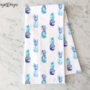 May include: White kitchen towel with a blue and teal pineapple pattern.