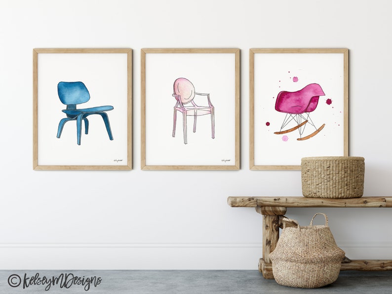 May include: Three watercolor illustrations of chairs. The first chair is blue and has a wooden base. The second chair is pink and has a metal frame. The third chair is pink and has a wooden base and rockers.