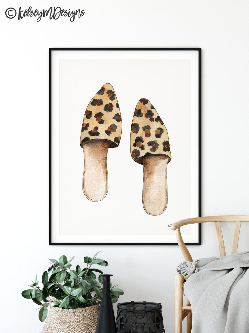 May include: A watercolor painting of a pair of leopard print slippers. The slippers are brown and black with a white background.