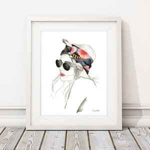 May include: A watercolor illustration of a woman with long, flowing hair wearing a black and red patterned headscarf and sunglasses. The background is white.