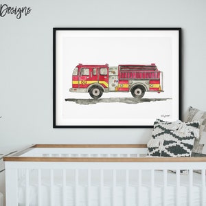 May include: Watercolor print of a red and yellow fire truck with black wheels, displayed in a black frame. The artwork is set against a white background. The print is hanging above a white crib.