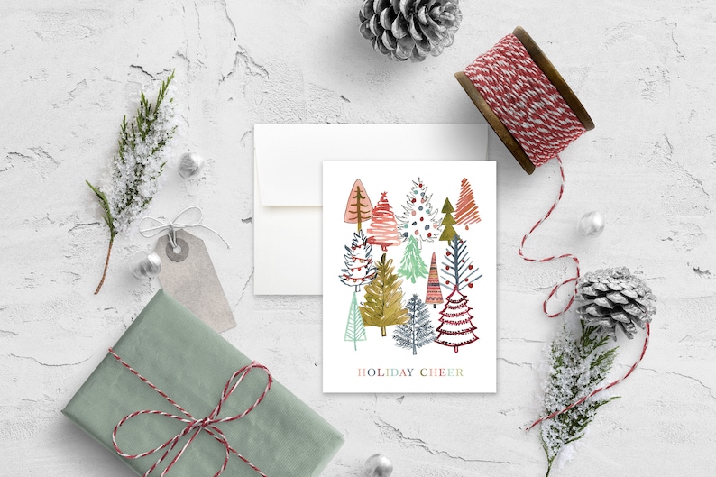 May include: A white card with a colorful illustration of a forest of stylized Christmas trees. The text "HOLIDAY CHEER" is printed at the bottom of the card.