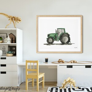 May include: A watercolor painting of a green tractor on a white background. The tractor is in profile view and has a black tire on the left side and a gray tire on the right side. The painting is framed in a light wood frame.