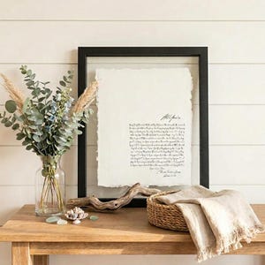 Personalized first dance song lyrics printed on handmade deckled-edge cotton paper and beautifully displayed in a premium float frame. This custom wedding keepsake features the lyrics from a couple's first dance song, creating a meaningful anniversary gift or wedding memory. Elegant home decor crafted from luxurious cotton paper with visible deckled edges. Perfect for weddings, anniversaries, newlyweds, and romantic gift-giving, preserving a special moment in timeless artwork.