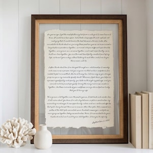 May include: A rectangular wooden frame containing a piece of off-white paper with deckled edges. The paper features black cursive text detailing a personal narrative about a six-year relationship, concluding with the date September 2, 2024.