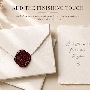 May include: A cream-coloured cotton envelope with a dark red wax seal featuring a compass design, paired with a matching deckle-edge card that reads A little note from me to you. The text ADD THE FINISHING TOUCH is printed at the top of the image.