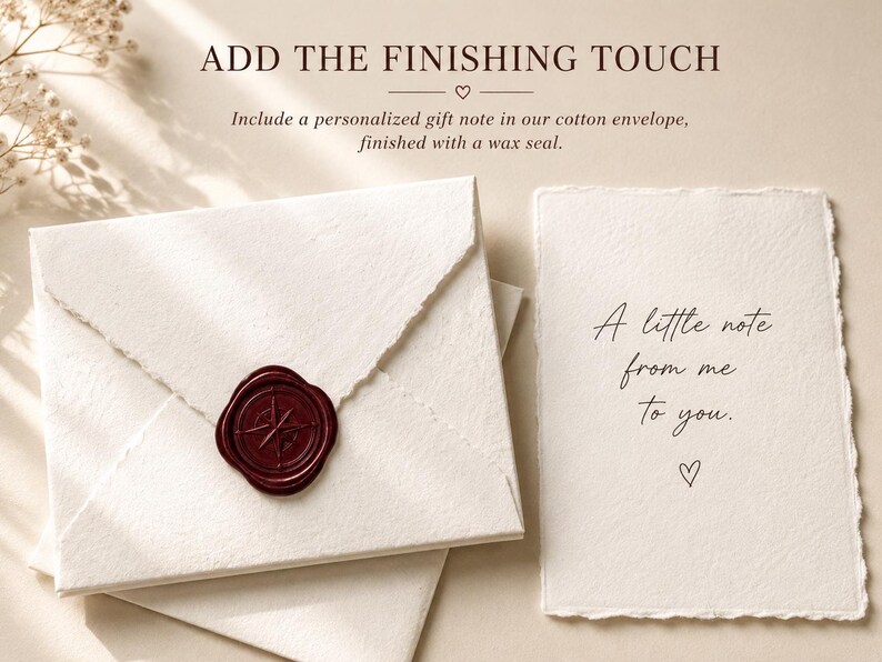 Peut inclure: Une enveloppe en coton couleur cr&egrave;me avec un sceau en cire rouge fonc&eacute; orn&eacute; d'une boussole, accompagn&eacute;e d'une carte &agrave; bords effiloch&eacute;s portant l'inscription A little note from me to you. Le texte ADD THE FINISHING TOUCH figure en haut.