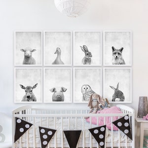 Puede incluir: Un conjunto de seis estampados de animales en blanco y negro en marcos blancos. Los estampados representan una oveja, un pato, un conejo, un zorro, un ciervo, un cerdo, un b&uacute;ho y un conejo. Los estampados est&aacute;n dispuestos en forma de cuadr&iacute;cula en una pared blanca sobre una cuna blanca con una almohada rosa y ropa de cama de lunares blancos y negros.