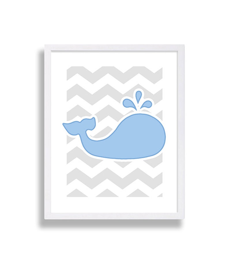 May include: A framed print with a light blue whale silhouette on a gray chevron background.