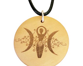 May include: A round, light-colored wooden pendant with a black cord. The pendant features a carved design of a female figure between two crescent moons, with Celtic knot and vine details. The pendant is approximately 2 inches in diameter.