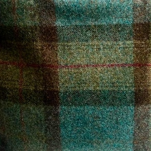 May include: A textured fabric featuring a plaid pattern in shades of teal, olive green, and dark brown. The weave displays a visible, slightly fuzzy surface with thin, horizontal and vertical red lines intersecting across the checkered design.